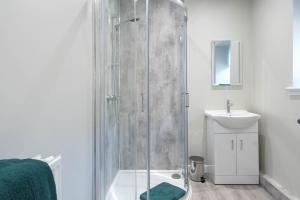 a bathroom with a glass shower and a sink at Almanythie Snug, Peterhead in Peterhead +21 photos