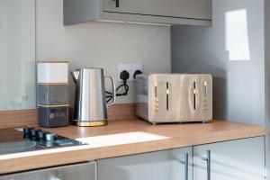 a kitchen counter with two toasters on a counter top at Almanythie Snug, Peterhead in Peterhead