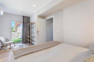 a bedroom with a bed and a chair and a window at Vila Santa Luzia 2 in Fátima