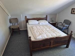 a bedroom with a bed with two pillows and a chair at Molenzicht in Elspeet