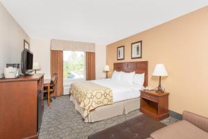 a hotel room with a bed and a television at Baymont by Wyndham Branson - On the Strip in Branson