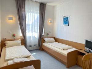 a hotel room with two beds and a television at Gasthof Kirchberger in Fürth