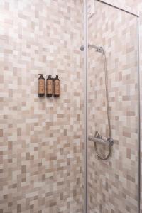 a shower with three shampoo bottles on the wall at RH Charming Apartment Liberdade I in Braga +55 photos