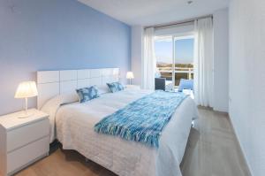 a bedroom with a large bed with a blue wall at AG Aiguablava Vista Mar in Playa de Gandia +97 photos
