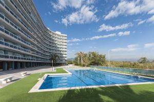 an apartment building with a swimming pool next to a building at AG Aiguablava Vista Mar in Playa de Gandia