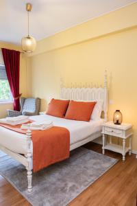 a bedroom with a large white bed and a chair at RH Charming Apartment Liberdade I in Braga