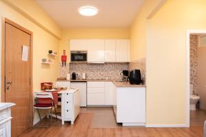 a kitchen with white cabinets and a table at RH Charming Apartment Liberdade I in Braga