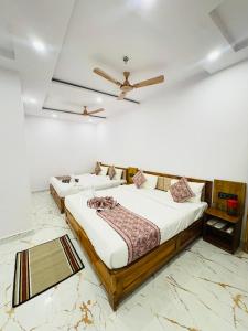 a bedroom with two beds and a ceiling fan at Hotel Shiva Darshanam in Varanasi