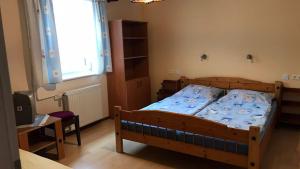 a bedroom with a bed and a table and a window at Chalupa Magdaléna in Terchová