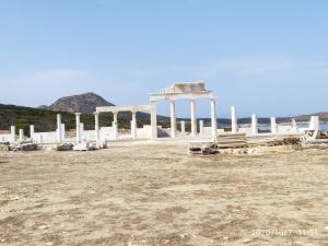 a white building with columns in a field at Cycladic residence, Saint George, Antiparos in Agios Georgios +6 photos