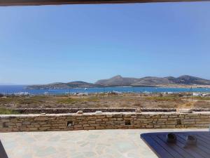 a stone wall with a view of the water at Cycladic residence, Saint George, Antiparos in Agios Georgios