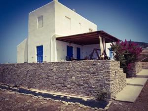 a white house behind a brick wall at Cycladic residence, Saint George, Antiparos in Agios Georgios