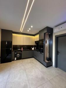 a large room with a kitchen with black cabinets at TRIO Chalet 2 in Sowayma