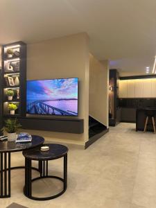 a living room with a large flat screen tv on a wall at TRIO Chalet 2 in Sowayma
