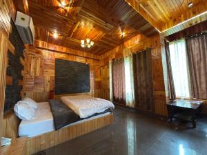 a bedroom with a bed in a room with wooden walls at The Rustic Jibhi - Backpackers Hostel in Jibhi
