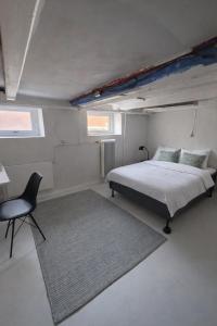a bedroom with a bed and a chair in it at Kysthus Villa Nexø in Neksø