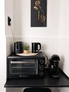 a black toaster oven sitting on a kitchen counter at Hera Exclusive Stay in Timişoara