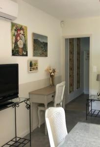 a living room with a table and chairs and a television at Clos Sainte Marguerite in Lambesc