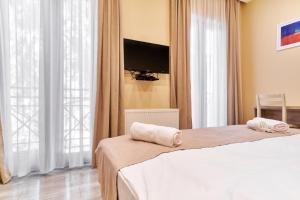 a bedroom with two beds and a flat screen tv at Hotel Date in Tbilisi City
