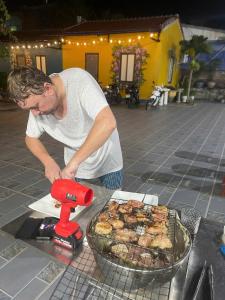 a man is preparing food on a grill at Windy Homestay in Cat Ba