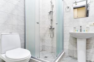 a bathroom with a shower and a toilet and a sink at Hotel Date in Tbilisi City