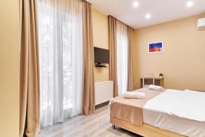 a bedroom with a bed and a large window at Hotel Date in Tbilisi City