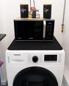 a microwave sitting on top of a washing machine at Hera Exclusive Stay in Timişoara
