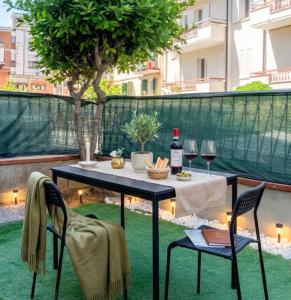 a table with a bottle of wine and two chairs at Deluxe Flat Empoli GVARO in Empoli