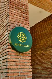a sign for a hotel date hanging on a brick wall at Hotel Date in Tbilisi City +56 photos