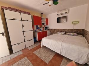 a bedroom with a bed and a kitchen with red cabinets at Casita Casa la Rambla in La Romana