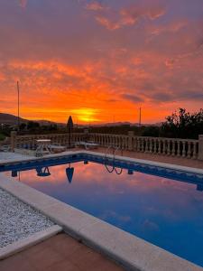 a swimming pool with a sunset in the background at Casita Casa la Rambla in La Romana
