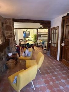a living room with yellow chairs and a fireplace at La Salera - Casa Rural in Saelices de la Sal