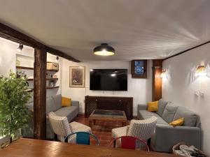 a living room with a couch and a tv at La Salera - Casa Rural in Saelices de la Sal