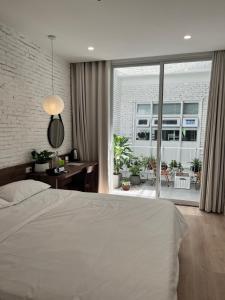 a bedroom with a white bed and a large window at 389 Hz Homestay in Danang