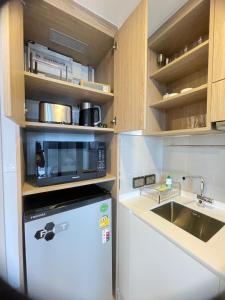 a small kitchen with a microwave and a refrigerator at Sky Park Laguna Phuket in Laguna Phuket