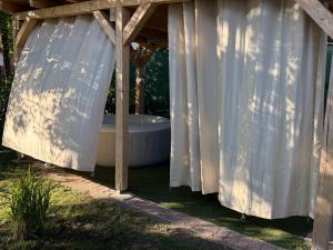 a bath tub sitting under a wooden pergola at Sparkling Time Apartman in Hajdúszoboszló