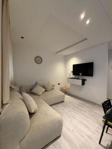 a living room with a couch and a flat screen tv at Appartement herrati in Kenitra