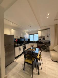a kitchen with a table and chairs in a room at Appartement herrati in Kenitra