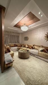 a large living room with couches and a chandelier at Appartement herrati in Kenitra