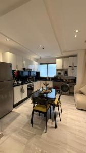 a kitchen with a table and chairs in a room at Appartement herrati in Kenitra