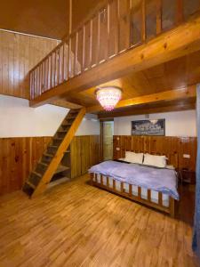 a bedroom with a large bed and a staircase at The Rustic Jibhi - Backpackers Hostel in Jibhi