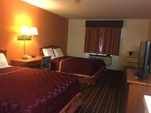 A bed or beds in a room at Texas Inn and Suites Lufkin