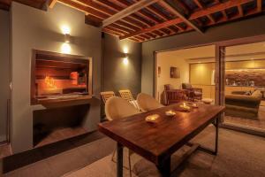 a living room with a wooden table and a fireplace at 17 Marine - Apt 103 - Private Hot Tub & Garden in Hermanus