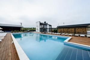 a large swimming pool with chairs and blue water at California Resort and SPA in Novoyavorivsk