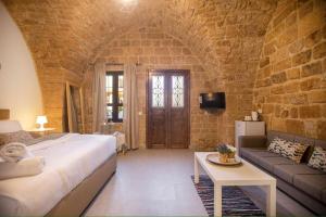 a bedroom with a bed and a couch and a table at Casa Gia By The Sea G1 & G2 in Batroûn