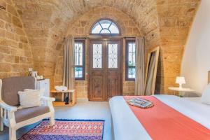 a bedroom with a bed and a chair and a door at Casa Gia By The Sea G1 & G2 in Batroûn