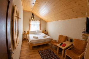 a bedroom with a bed and a couch and a chair at Nebesa Hotel EZ in Chimgan