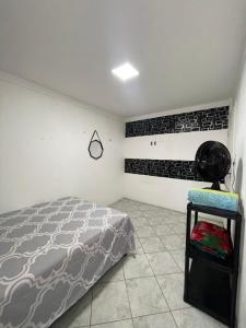 a bedroom with a bed and a chair in it at House farol in Aracaju