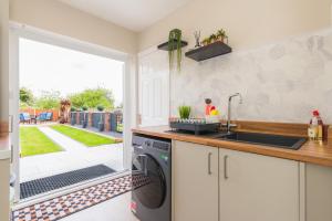 a kitchen with a washer and dryer and a patio at Heath Lodge in Stockingford