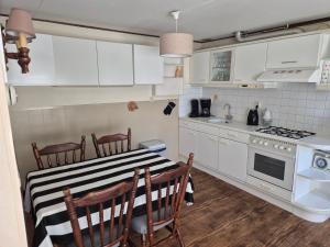 a kitchen with a black and white table and chairs at Molenzicht in Elspeet
